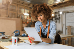 Empreendedora analisando seu site em um tablet, simbolizando autonomia digital e controle sobre seu negócio.
